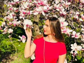 Woman touching flowers blooming in tree