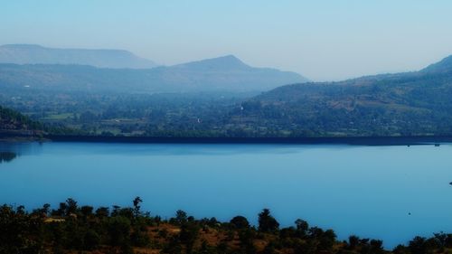 Scenic view of lake and mountains against clear sky