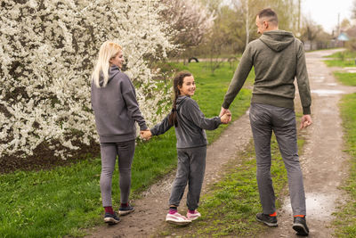 Rear view of couple walking on field