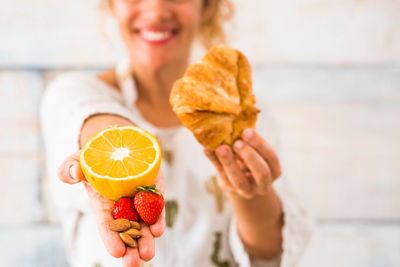 Midsection of woman holding orange