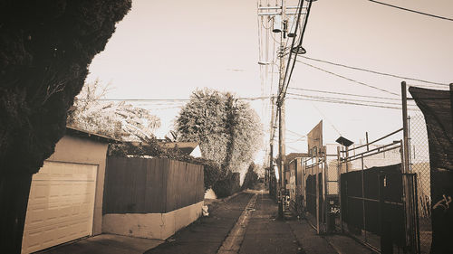 Alley amidst buildings in city against clear sky