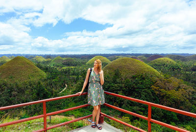 Rear view of woman walking on mountain against sky