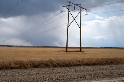 Electricity pylon on field against sky