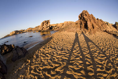 Scenic view of rocky beach against clear sky