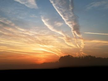 Silhouette landscape against romantic sky at sunset