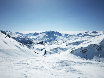 Scenic view of snow mountains against blue sky