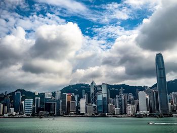 Sea by buildings against sky in city