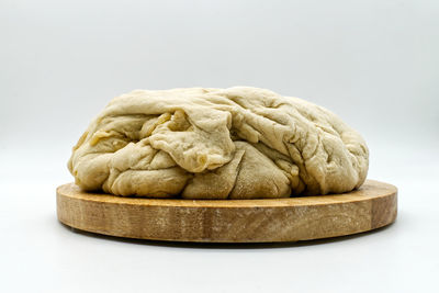 Close-up of bread on table against white background