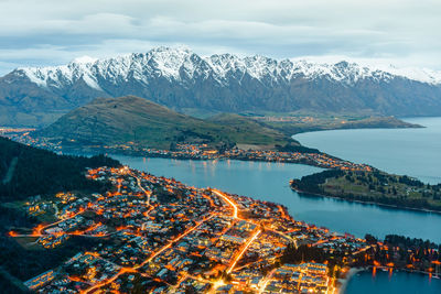 Scenic view of lake by snowcapped mountains against sky