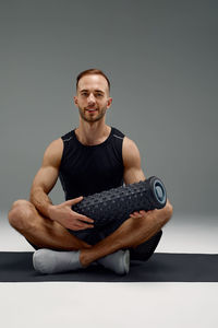 Portrait of young man exercising at home