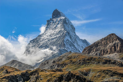 Scenic view of rocky mountains against blue sky