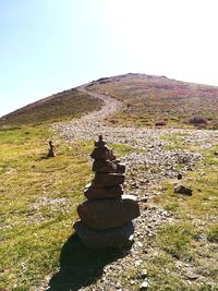 Stack of rocks on land against sky