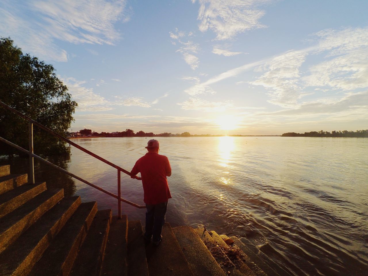 sky, water, real people, one person, railing, cloud - sky, lifestyles, beauty in nature, sunset, nature, leisure activity, standing, scenics - nature, sunlight, men, tranquility, full length, tranquil scene