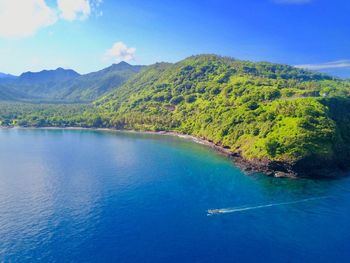 Scenic view of sea and mountains against sky