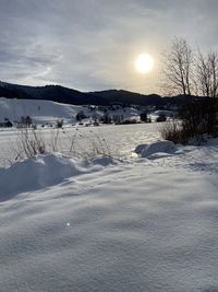 Scenic view of snow covered landscape against sky during sunset