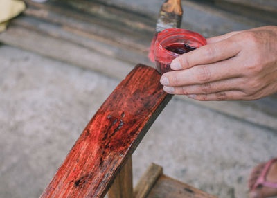 Cropped hand of person painting chair