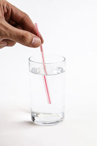 Hand holding glass over white background