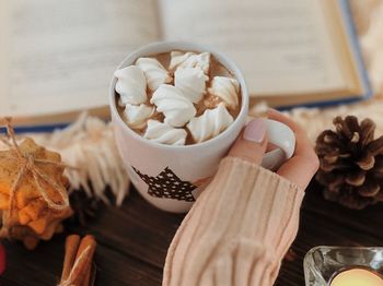 Cropped hand of woman holding drink on table during christmas