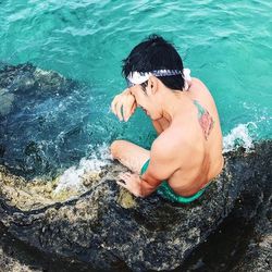 High angle view of shirtless boy in sea