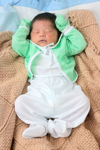 High angle view of baby sleeping in bed