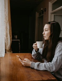 Young woman using mobile phone at home