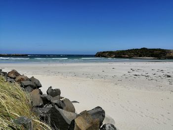 Scenic view of beach against clear blue sky