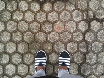 Low section of person standing on tiled floor