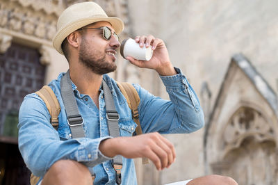 Full length of young man drinking glass