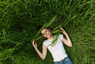 Portrait of young woman sitting on grassy field