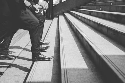 Low section of businessmen climbing on steps