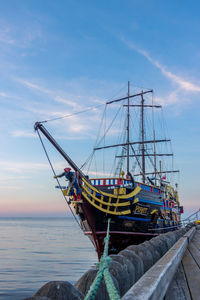 Fishing boat moored in sea against sky