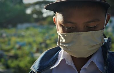 A child wears a mask while looking down