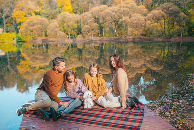 Group of people sitting at park during autumn