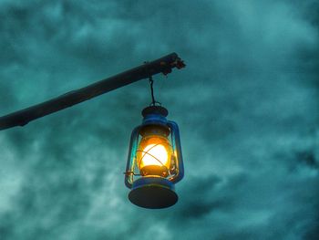 Low angle view of illuminated light bulb against sky