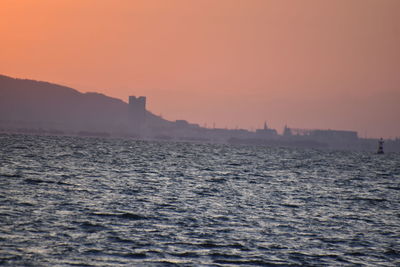 Scenic view of sea against orange sky