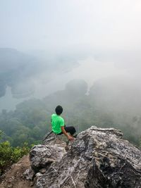 Man on rock against sky