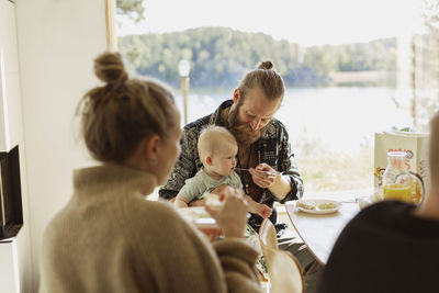 Man feeding baby son during breakfast