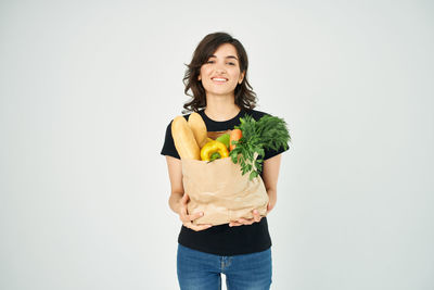 Portrait of smiling young woman against white background