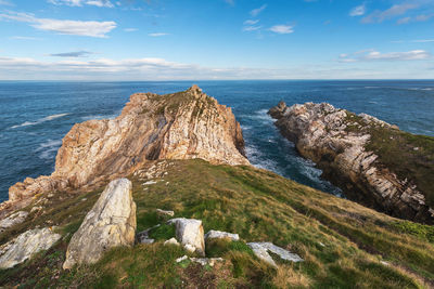 Rock formations by sea against sky