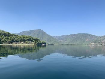 Scenic view of lake against clear blue sky