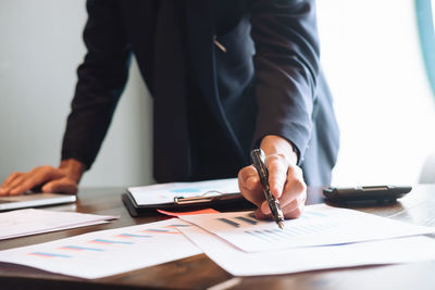 Midsection of man working on table