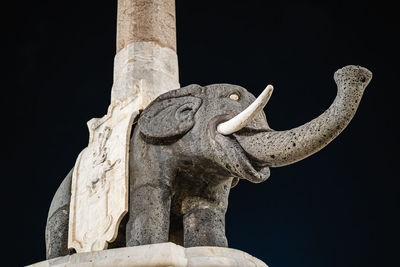 Low angle view of statue against black background