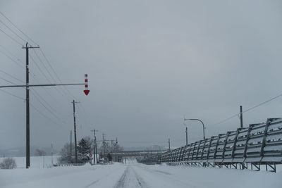 View of snow covered road against cloudy sky