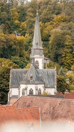 High angle view of cross amidst trees and buildings