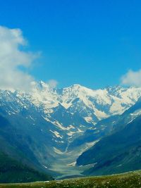 Scenic view of mountains against blue sky