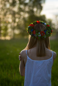 Rear view of woman standing by flowering plants