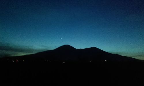 Scenic view of silhouette mountain against sky at night