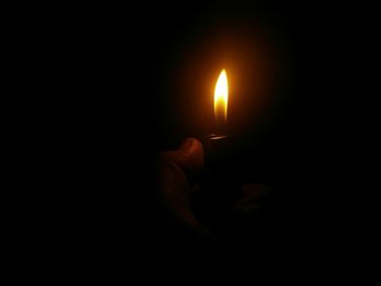 Close-up of lit candle in dark room