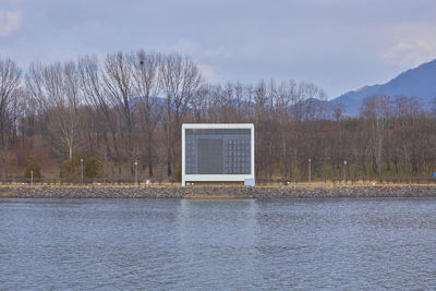 Built structure by lake against sky