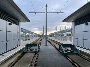 Railroad tracks in city against sky